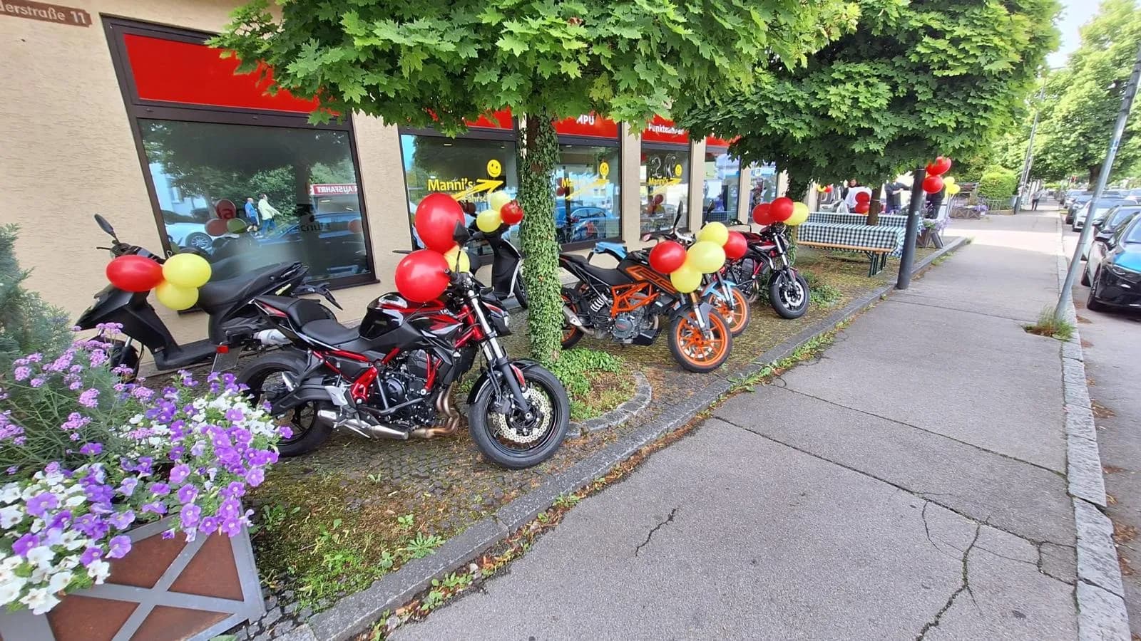 Schulungsmotorräder mit rot-gelben Ballons vor der Fahrschule in Herrsching